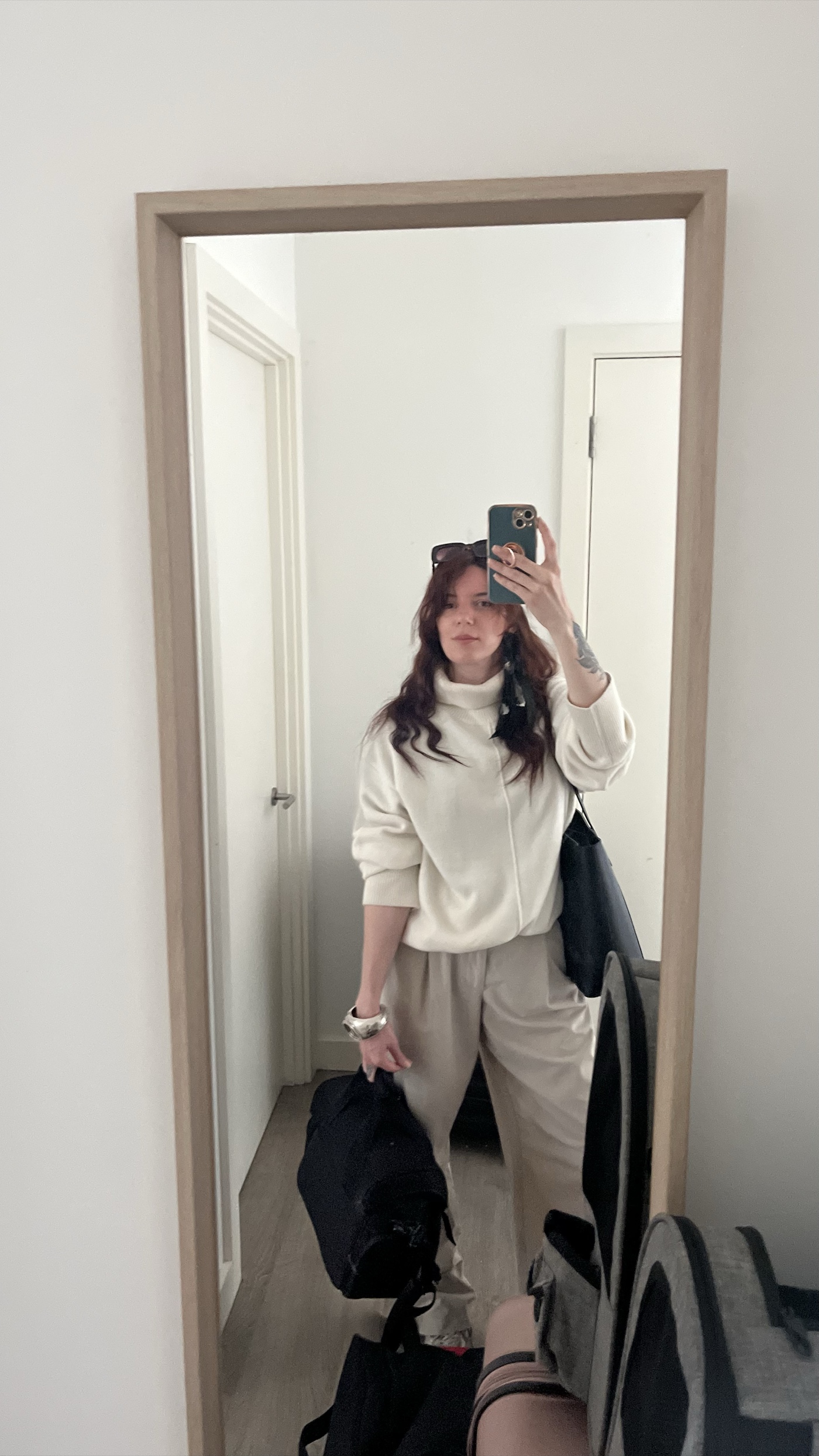 Mag in a mirror selfie, camera bag in hand, on her way to a shoot